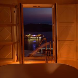a room with a window looking out at the water at Elia Family Suites in Fira