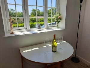 a table with two wine glasses and a window at Sylvan Seas in Whitwell