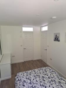 a bedroom with two white doors and a bed at Sylvan Seas in Whitwell