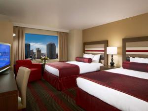 Enticing Stay at Strat Casino STRIP Las Vegas في لاس فيغاس: غرفة فندقية بسريرين وتلفزيون بشاشة مسطحة