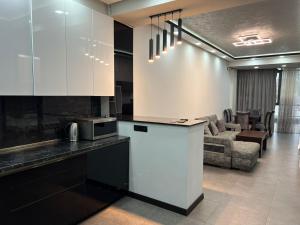 a kitchen with white cabinets and a living room at DELUXE Modernly Renovated 2 Bedroom + 2 Bathroom Apt by REPUBLIC SQUARE in Yerevan