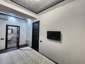 a living room with a tv on a white wall at DELUXE Modernly Renovated 2 Bedroom + 2 Bathroom Apt by REPUBLIC SQUARE in Yerevan