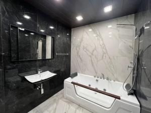 a bathroom with a sink and a bath tub and a sink at DELUXE Modernly Renovated 2 Bedroom + 2 Bathroom Apt by REPUBLIC SQUARE in Yerevan +32 photos