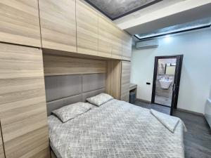a bedroom with a large bed with a wooden wall at DELUXE Modernly Renovated 2 Bedroom + 2 Bathroom Apt by REPUBLIC SQUARE in Yerevan