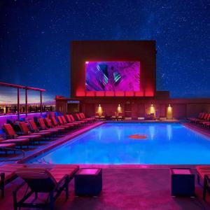 einen großen Pool mit Stühlen und einem großen Bildschirm in der Unterkunft Enticing Stay at Strat Casino STRIP Las Vegas in Las Vegas