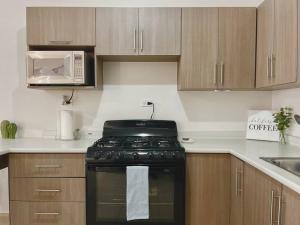 a kitchen with a stove and a microwave at Condominiums Boutique Madera 3 in Ciudad Juárez