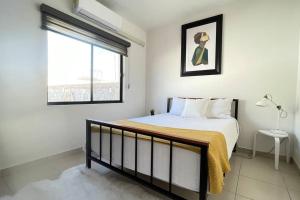 a white bedroom with a bed and a window at Condominiums Boutique Madera 3 in Ciudad Juárez