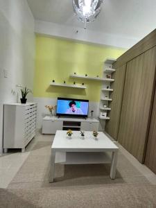 a living room with a tv and a white table at Night Blink Staycation and Rentals in Manila