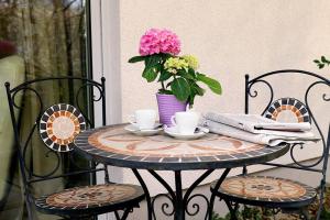 una mesa con dos tazas y un jarrón de flores en ☆Luxuriöses Apartment☆ Central MUC Enjoy & relax en Múnich