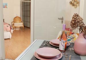 a table with pink plates and a bottle of wine at ☆Luxuriöses Apartment☆ Central MUC Enjoy & relax in Munich