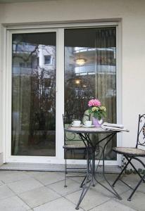 una mesa con flores delante de una ventana en ☆Luxuriöses Apartment☆ Central MUC Enjoy & relax en Múnich