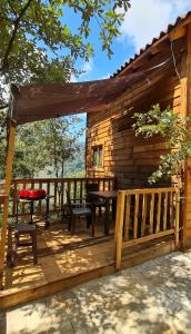 a wooden cabin with a table and bench on a deck at Mariposa - Cabañas Puerto del Zopilote in Pinal de Amoles