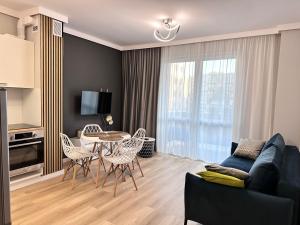 a living room with a couch and a table and chairs at Platinum De Lux Apartament in Stargard