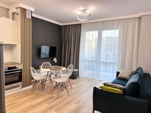 Una sala de estar con un sofá, una mesa y sillas. en Platinum De Lux Apartament, en Stargard
