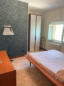 a bedroom with a bed and a lamp and a wall at Casa Turbigo-Malpensa-Milano in Turbigo +13 photos
