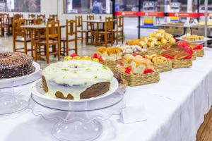uma mesa com bolos e cestos de comida em Hotel Caminho do Rosário em Aparecida