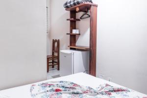 1 dormitorio con 1 cama y nevera blanca en Hotel Caminho do Rosário, en Aparecida