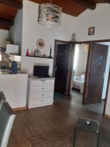 a living room with a white dresser and a bedroom at Petite maison in Lecci