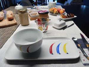 un tavolo con un piatto con una tazza e una ciotola di GOUEL-BRAS a Sarzeau