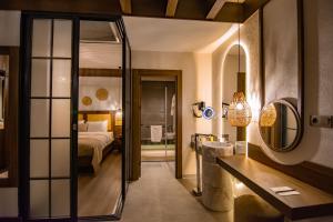 Hayal Vadisi Suite Hotel في طرابزون: غرفة نوم بسرير وحمام مع مرآة