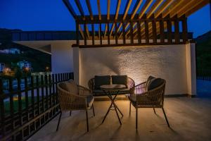 Un patio con sillas y una mesa en el balcón. en Hayal Vadisi Suite Hotel en Trebisonda
