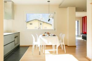 uma cozinha e sala de jantar com uma mesa branca e cadeiras em Style apartments VdA em Senin