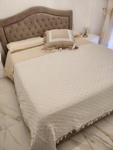 uma cama com um edredão branco e almofadas em Casa comfort zone em Perugia