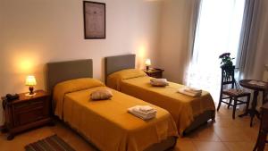 2 Betten in einem Zimmer mit gelber Bettwäsche in der Unterkunft Palazzo Zimatore Residenza D'Epoca in Pizzo