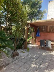 a patio with two chairs and an umbrella at Petite maison in Lecci