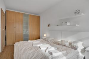 - une chambre blanche avec un grand lit et des oreillers blancs dans l'établissement Horský Apartmán Klínovec 4, à Loučná pod Klínovcem