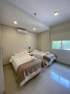 1 Schlafzimmer mit 2 Betten und einem Fenster in der Unterkunft Realty Del Maestro in Asunción