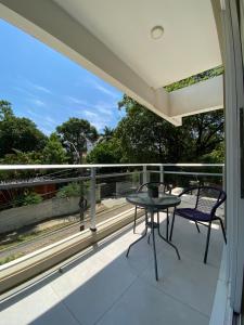 un patio con tavolo e sedie sul balcone. di Realty Del Maestro ad Asunción