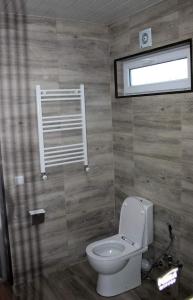 a bathroom with a white toilet and a window at Shemoqmedi chalet 