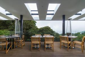 ein Esszimmer mit Tischen und Stühlen und einem großen Fenster in der Unterkunft Koora Monteverde-a Cloud Forest Hotel by Sandglass in Monteverde Costa Rica