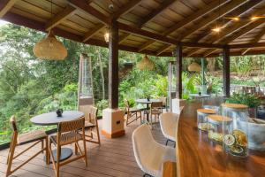 eine Terrasse mit Tischen und Stühlen auf einer Holzterrasse in der Unterkunft Koora Monteverde-a Cloud Forest Hotel by Sandglass in Monteverde Costa Rica
