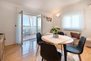 a living room with a table and chairs in a room at Apartments Sunliving in Vilanija