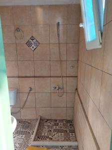 ein Bad mit einer Dusche und Fliesenboden in der Unterkunft Paradise lost in Kalamata