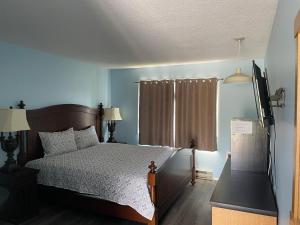 a bedroom with a bed and a television in it at Y-5 Motel in Barrière