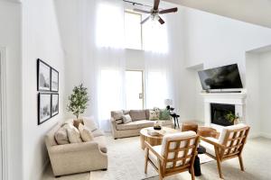 a living room with white furniture and a fireplace at Calming 4-bedroom with fireplace & game room in Little Elm
