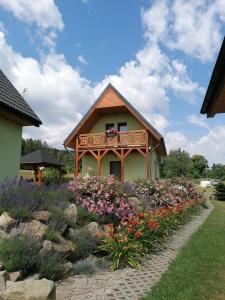 a small house with a balcony in a garden at Domki pod Derkaczem in Radków