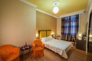 a bedroom with a bed and two chairs at Delphi Art Hotel by Prima Hotels in Athens