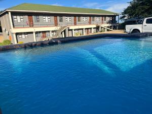 una grande piscina di acqua blu di fronte a un edificio di Sunset lodge a Manguzi