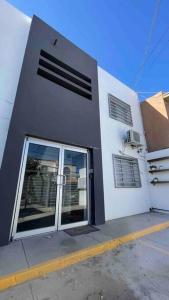 a gray and white building with a door and windows at •Executive Suite• Quiet, Centrally & Comfortable in Ciudad Juárez