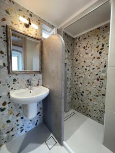 ein Bad mit einem Waschbecken und einem Spiegel in der Unterkunft KROISSOS in Galissas