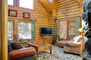 una sala de estar con TV en una cabaña de madera en Lacys Log Cabin Alto Home with Mountain Views! en Alto