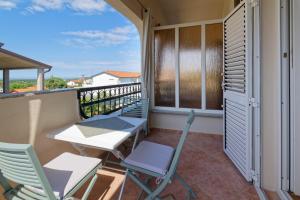 a balcony with chairs and a table and chairs at Apartments Sunliving in Vilanija