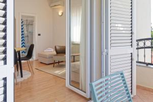 a room with a sliding glass door and a chair at Apartments Sunliving in Vilanija