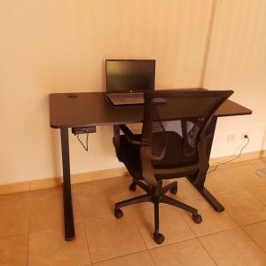 escritorio con silla y ordenador portátil en Beauty Apartment near Messe City and Airport with Garden, en Colonia