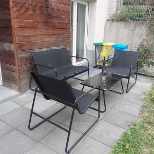 três cadeiras e uma mesa num pátio em Beauty Apartment near Messe City and Airport with Garden em Colônia