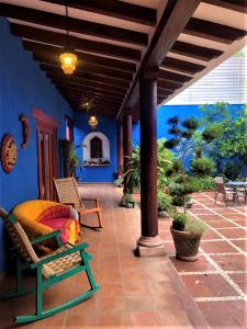 a patio with chairs and a blue wall at Casa Coco in Pátzcuaro
